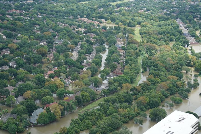 Suburban homes lined with trees and streets flooded day after a hurricane