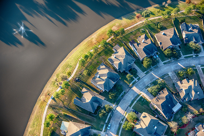 Aerial view of a suburban residential subdivision, located near water.